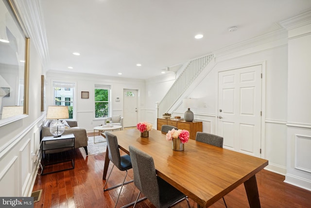 dining space with ornamental molding and dark hardwood / wood-style floors