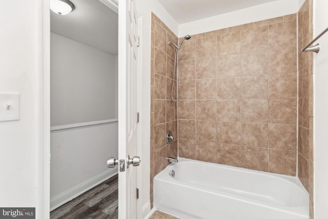 bathroom featuring tiled shower / bath and hardwood / wood-style flooring