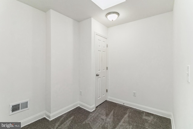 carpeted spare room featuring a skylight