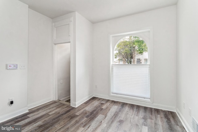 unfurnished room with dark wood-type flooring