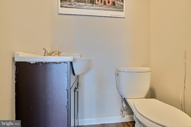 bathroom with hardwood / wood-style flooring, vanity, and toilet