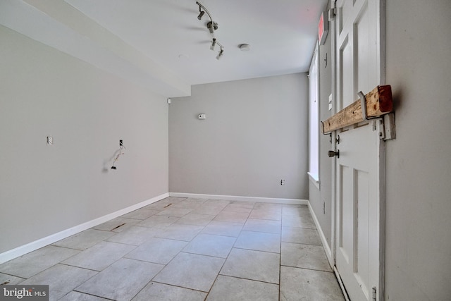 empty room with light tile patterned floors and rail lighting