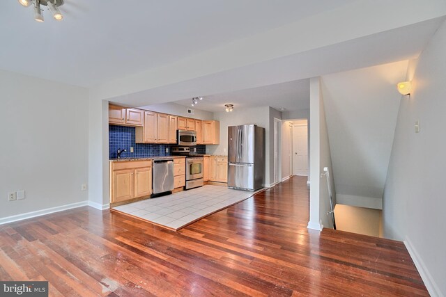 kitchen featuring stainless steel appliances, light hardwood / wood-style floors, backsplash, light brown cabinetry, and sink