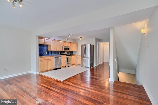 kitchen featuring sink, backsplash, stainless steel appliances, light hardwood / wood-style floors, and light brown cabinets