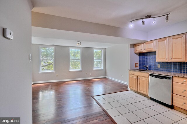 kitchen with decorative backsplash, dishwasher, light hardwood / wood-style floors, rail lighting, and light brown cabinets