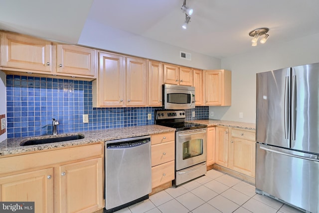 kitchen with appliances with stainless steel finishes, light brown cabinetry, sink, backsplash, and light tile patterned floors