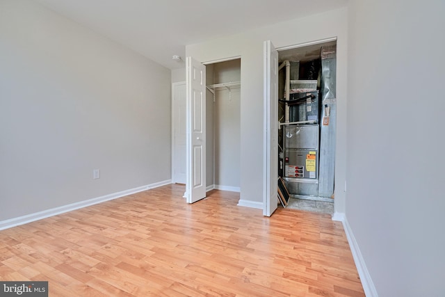 unfurnished bedroom featuring light hardwood / wood-style flooring and a closet