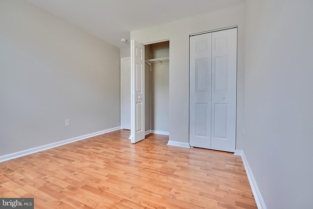 unfurnished bedroom with light wood-type flooring and two closets