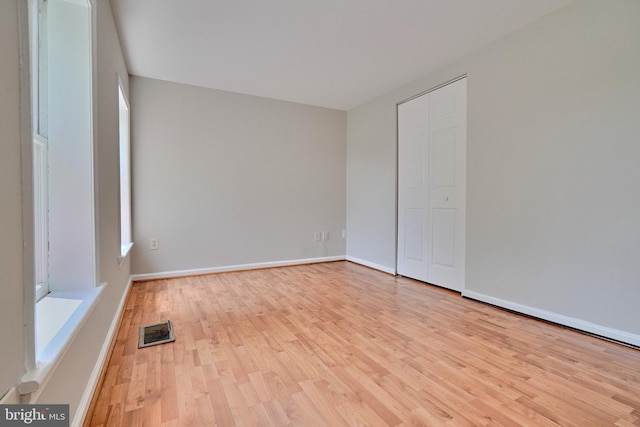 unfurnished bedroom with a closet and light hardwood / wood-style flooring