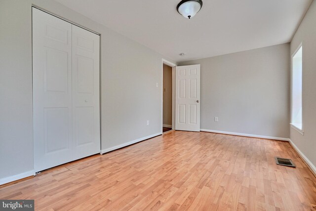 unfurnished bedroom featuring a closet and light hardwood / wood-style floors