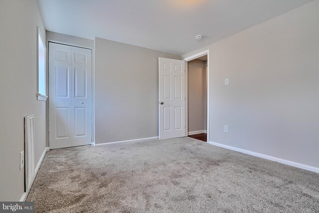 unfurnished bedroom with a closet and carpet floors