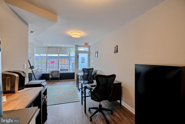 home office with a wall of windows and hardwood / wood-style floors