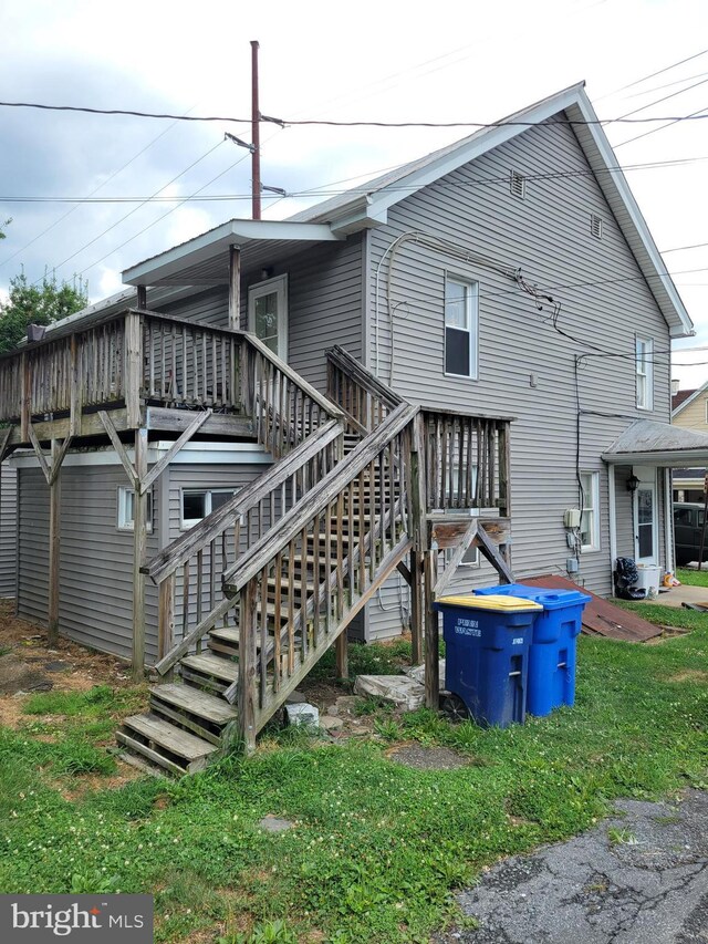 rear view of house featuring a wooden deck