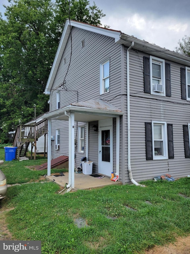 view of side of property with cooling unit, a patio area, and a lawn