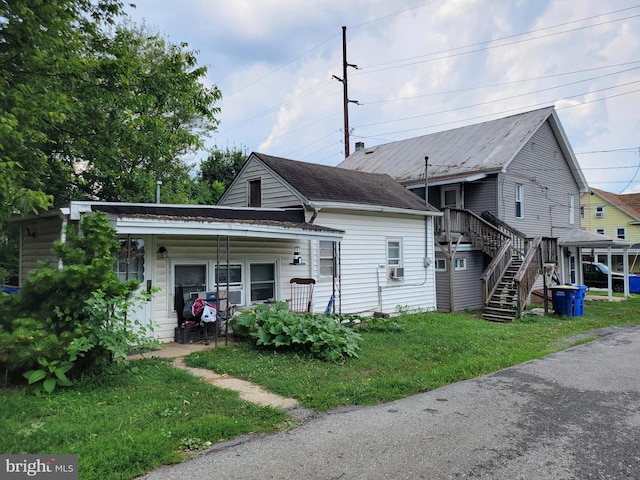 back of property featuring cooling unit, a yard, and covered porch