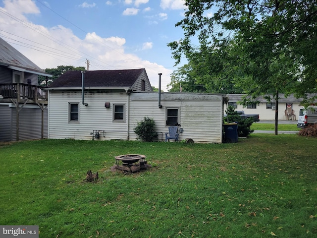 rear view of house featuring a yard and a fire pit