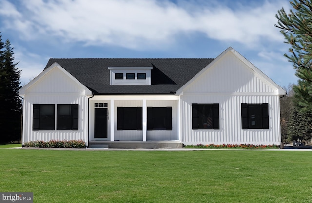 rear view of house featuring roof with shingles and a yard