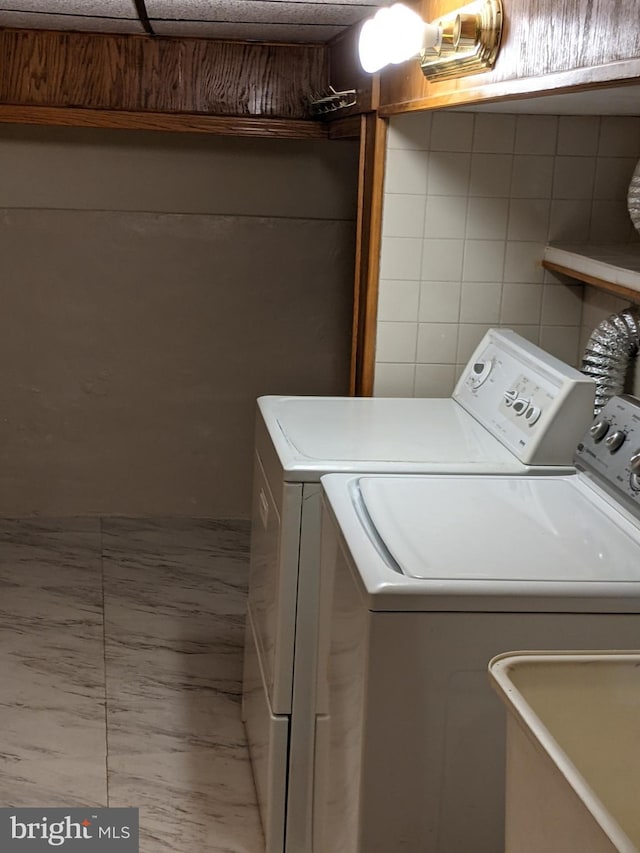 laundry room with sink, tile walls, independent washer and dryer, and tile patterned floors