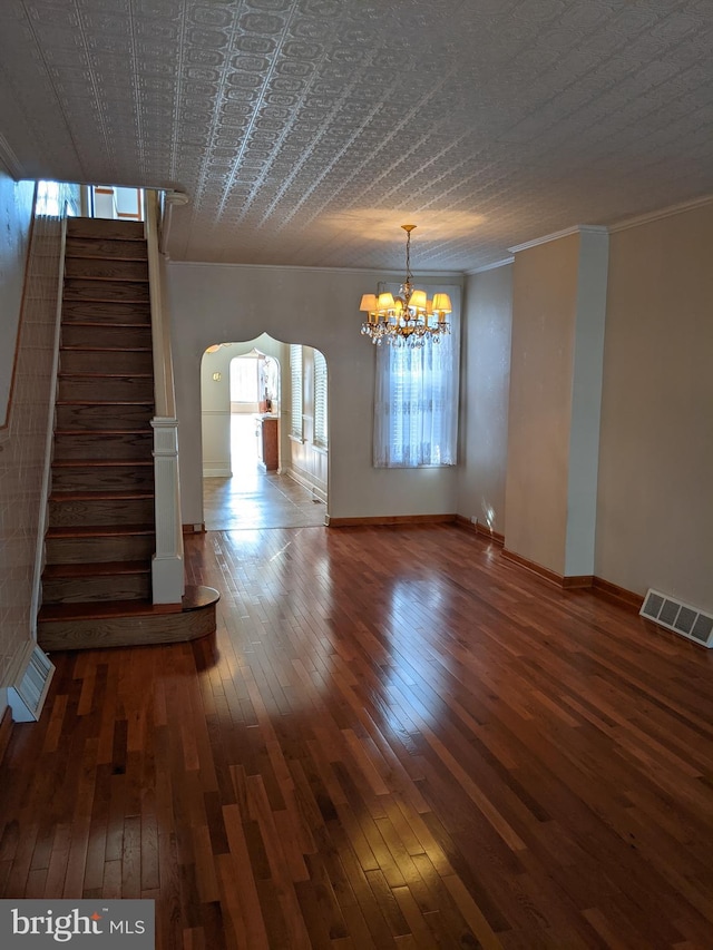 interior space with ornamental molding, a notable chandelier, and hardwood / wood-style flooring