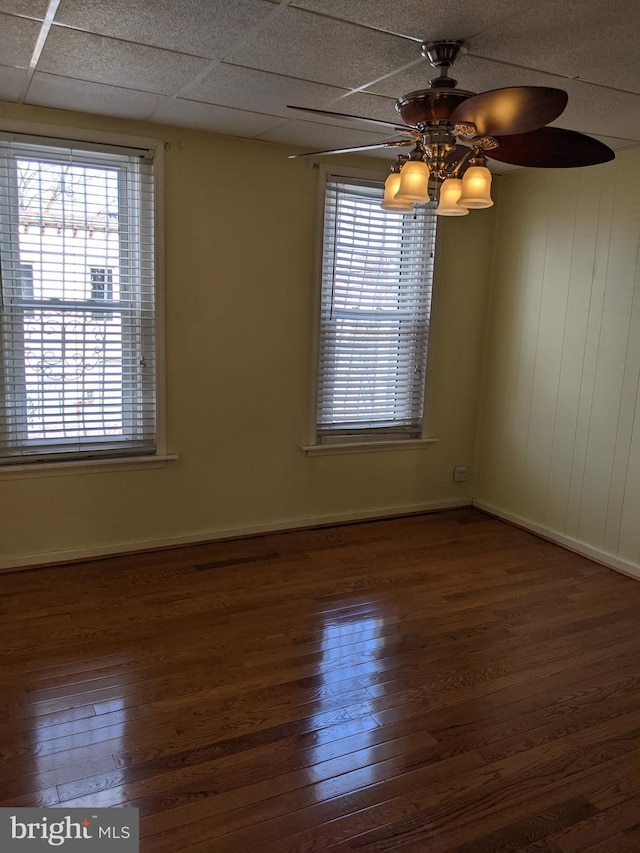 empty room with hardwood / wood-style flooring, a paneled ceiling, and ceiling fan