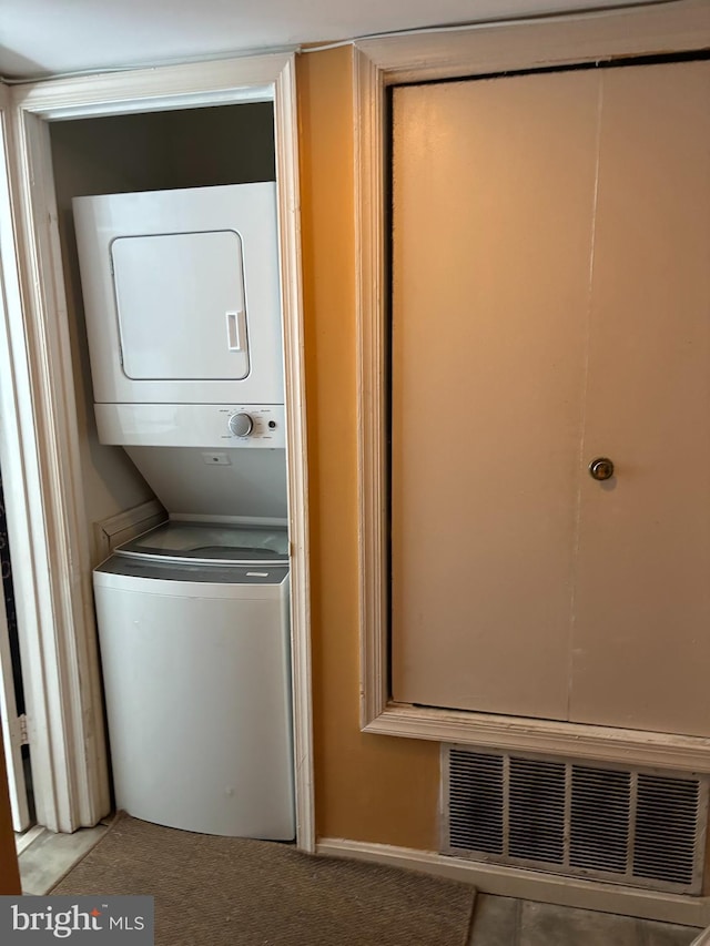 laundry room featuring stacked washer / drying machine