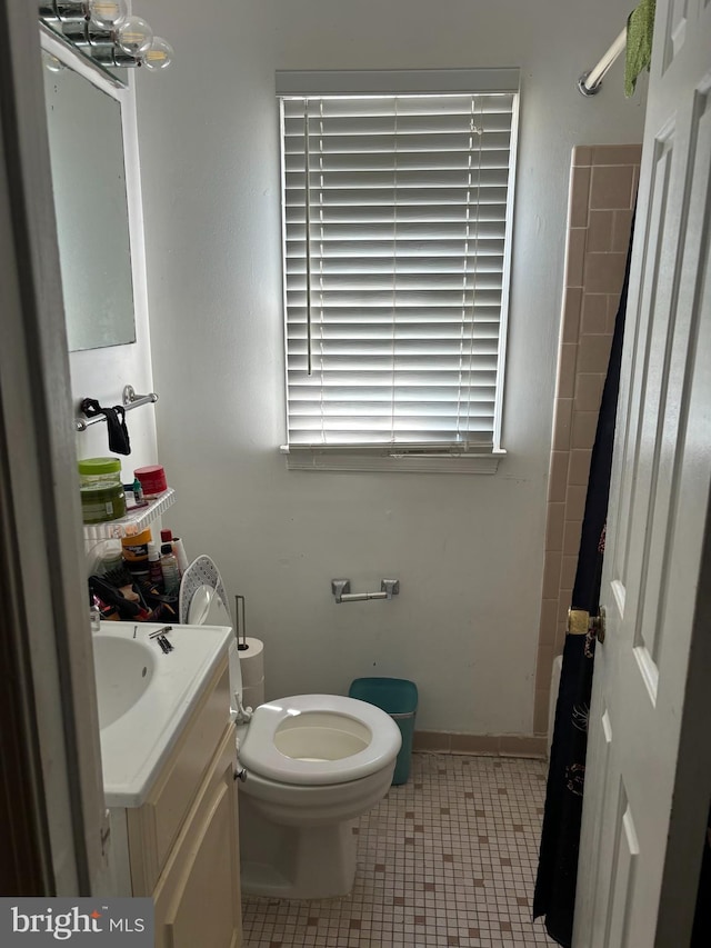 bathroom featuring a shower with curtain, vanity, tile patterned flooring, and toilet