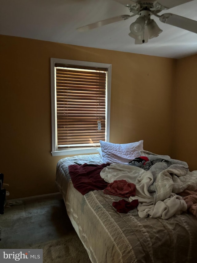 bedroom featuring ceiling fan and dark carpet