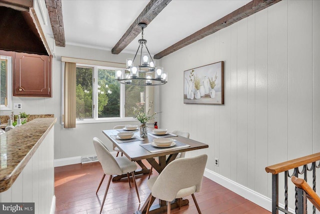 dining room featuring beamed ceiling, hardwood / wood-style floors, and a chandelier