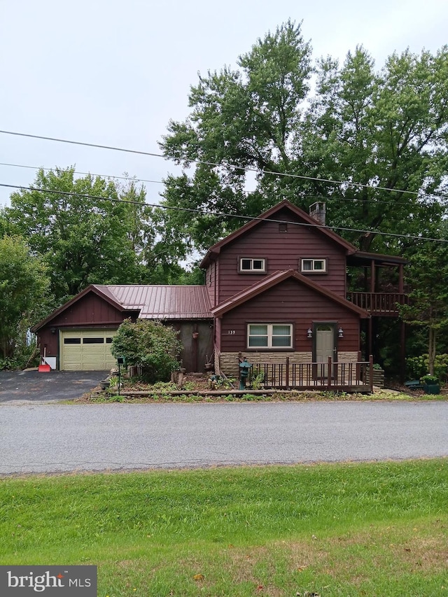 log cabin with a wooden deck and a garage