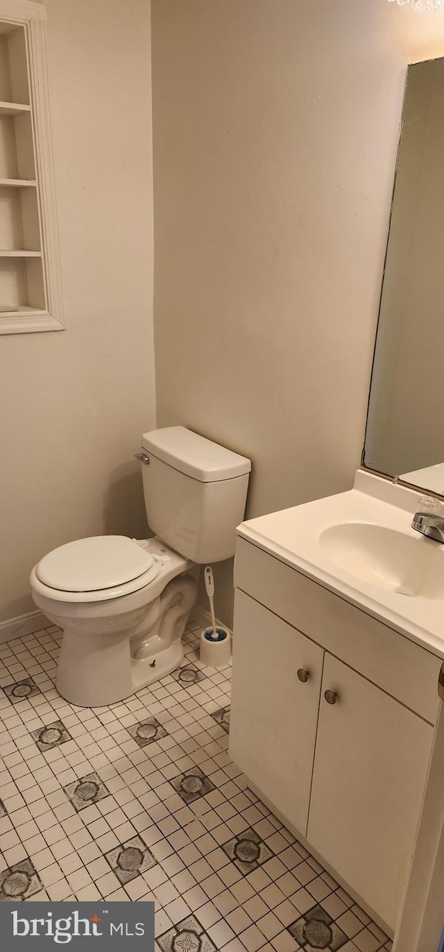 bathroom with tile patterned flooring, vanity, and toilet