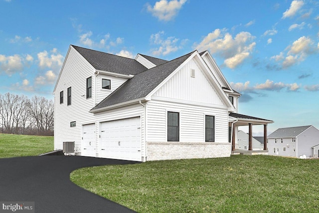 view of home's exterior featuring a yard, a garage, and central AC unit