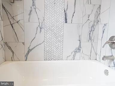 interior space featuring tiled shower / bath combo