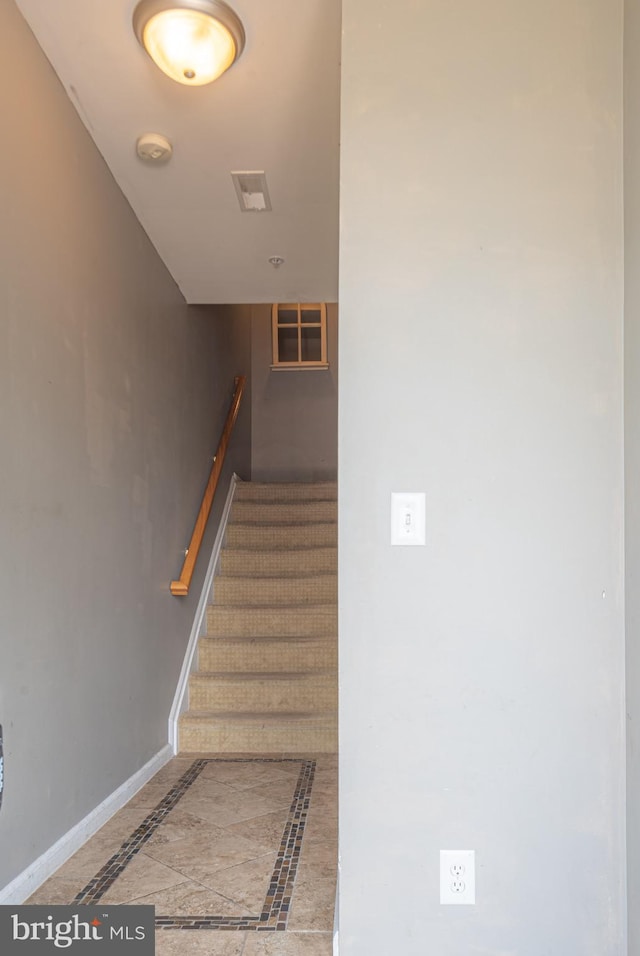 stairway with tile patterned floors