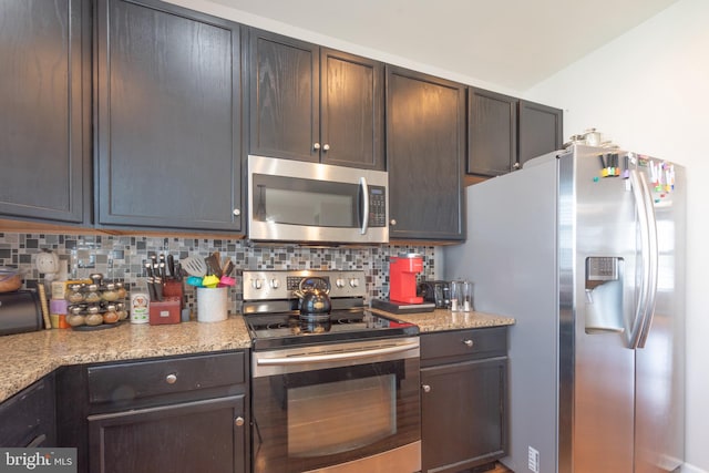 kitchen with tasteful backsplash, light stone counters, dark brown cabinets, and stainless steel appliances