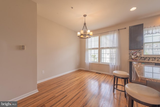 dining area featuring light hardwood / wood-style flooring and a chandelier