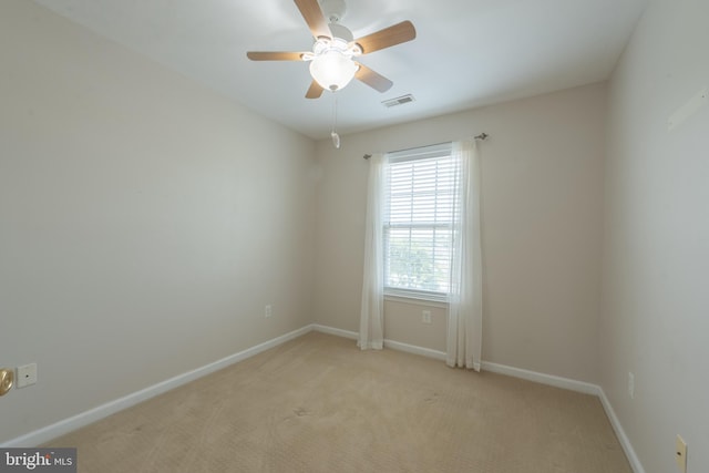 spare room featuring ceiling fan and light carpet