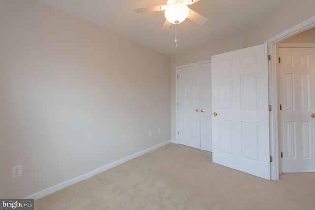 unfurnished bedroom with ceiling fan, a closet, and light carpet