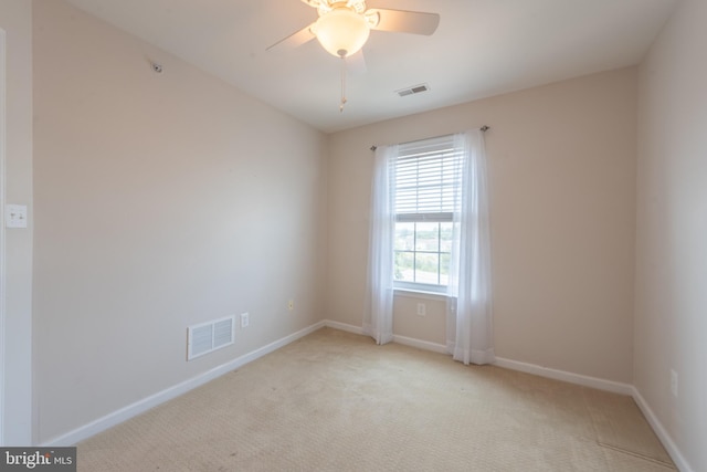 spare room with ceiling fan and light carpet