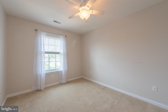 empty room featuring ceiling fan and light carpet