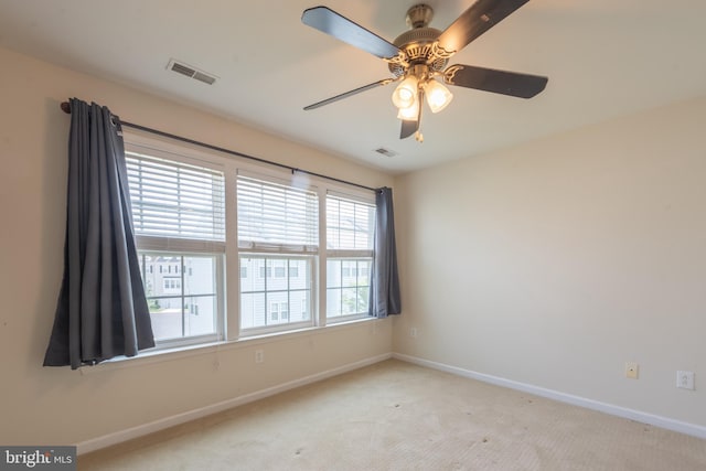 empty room featuring ceiling fan and light carpet