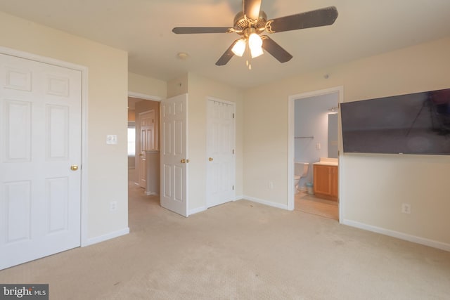 unfurnished bedroom featuring light colored carpet, connected bathroom, and ceiling fan