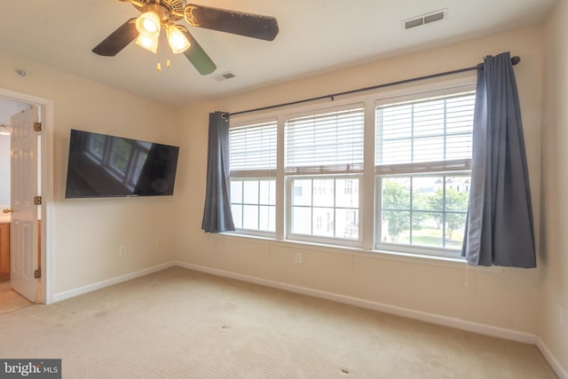 unfurnished room featuring ceiling fan and light carpet