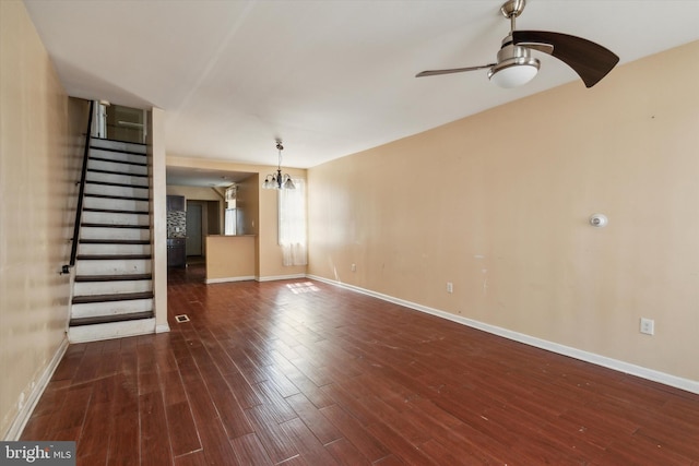 unfurnished living room with dark hardwood / wood-style flooring and ceiling fan with notable chandelier