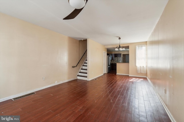 unfurnished living room featuring wood-type flooring and a notable chandelier