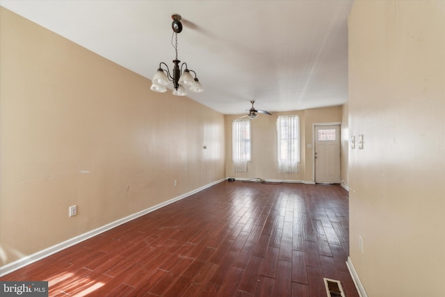 spare room featuring dark hardwood / wood-style flooring and ceiling fan with notable chandelier