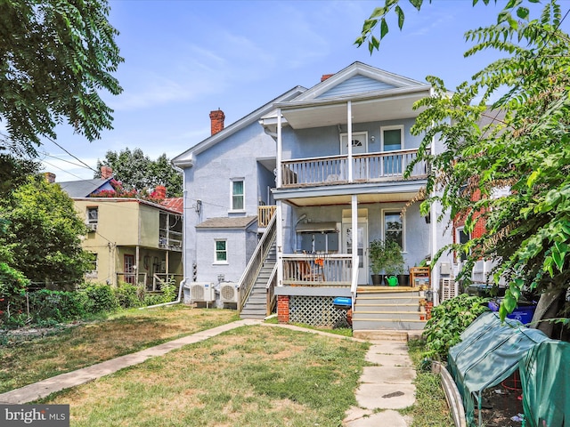 view of front of house with a balcony and a front yard