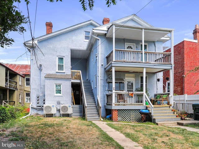 view of front of property with ac unit and a front lawn