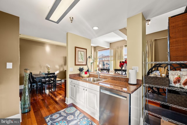 kitchen with sink, dishwasher, dark stone counters, white cabinets, and dark wood-type flooring