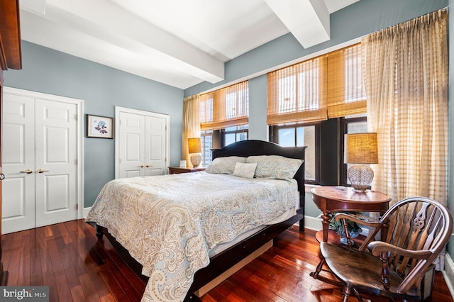 bedroom with dark wood-type flooring and beamed ceiling