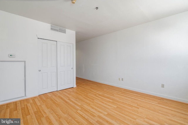 unfurnished bedroom featuring light hardwood / wood-style floors and a closet